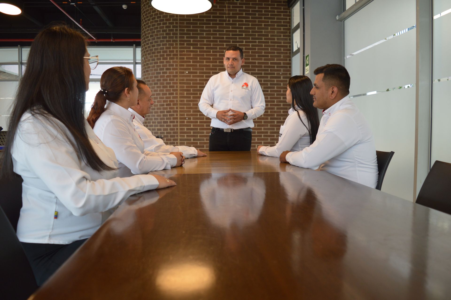 Un grupo de personas están sentadas alrededor de una mesa en una sala de conferencias.