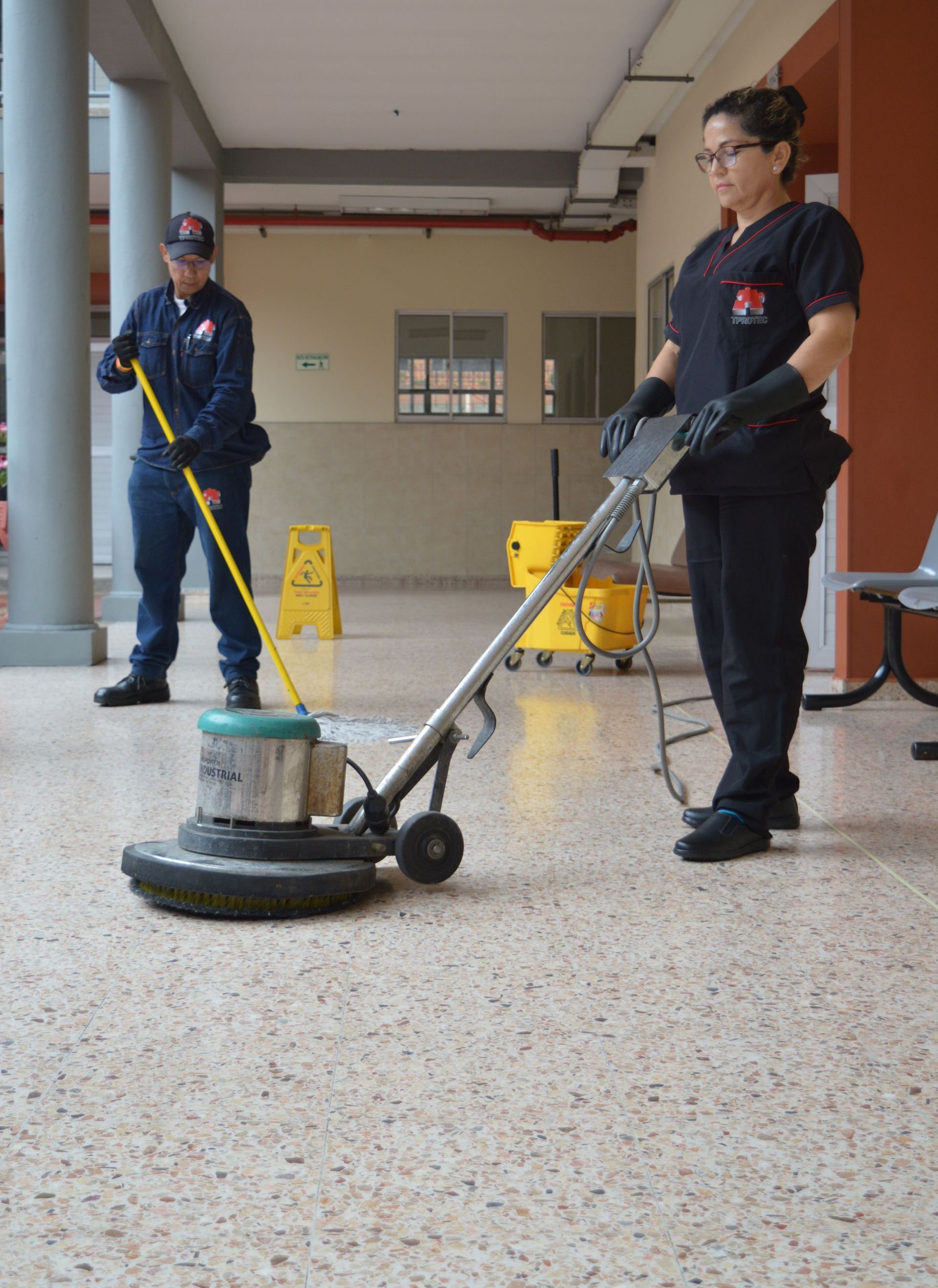 Una mujer está usando una máquina para limpiar el piso.