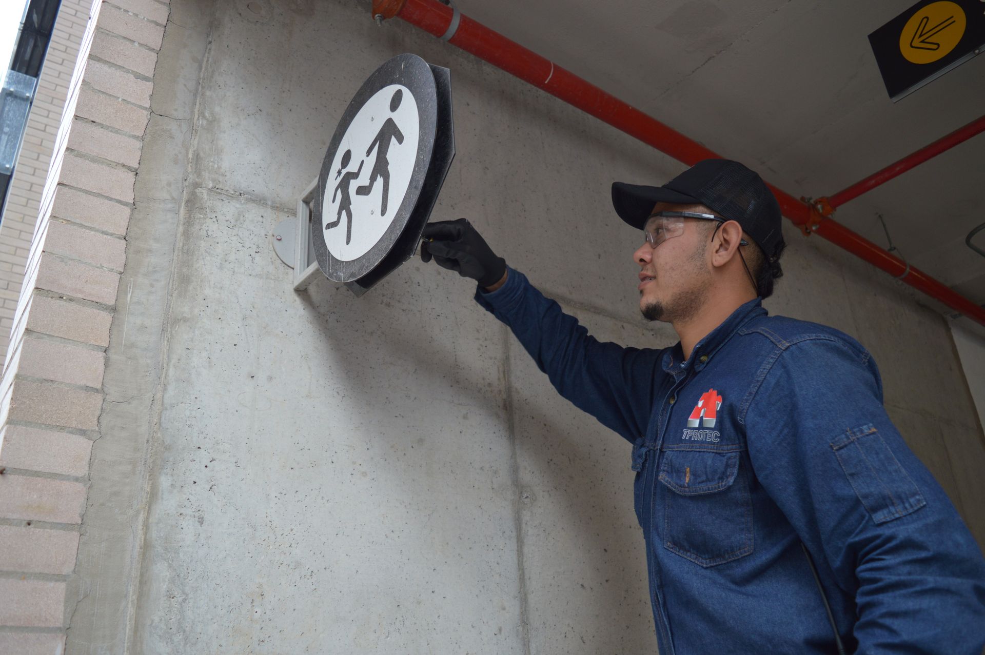 Un hombre señala un cartel en una pared.