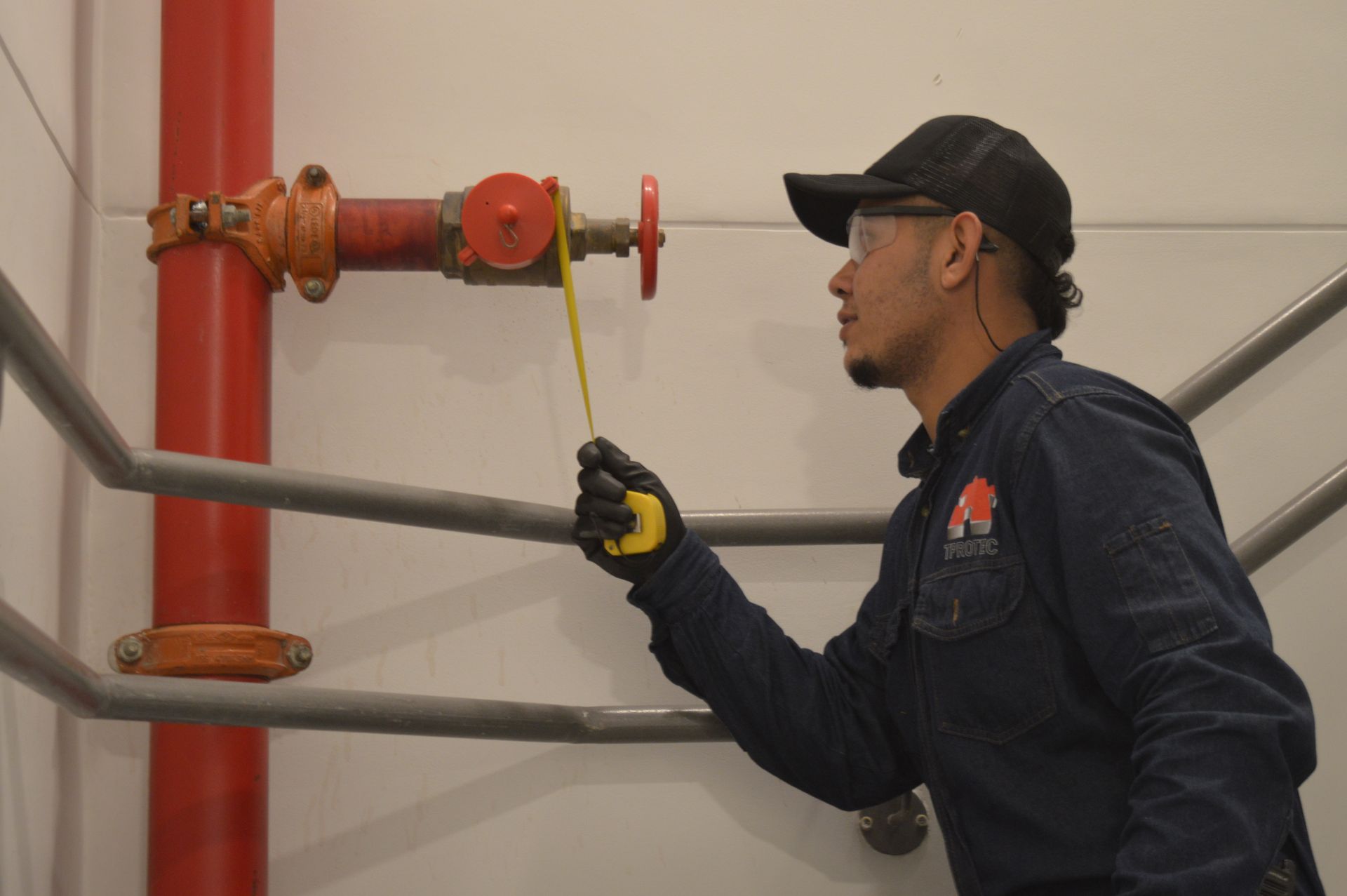 Un hombre está midiendo una tubería con una cinta métrica.