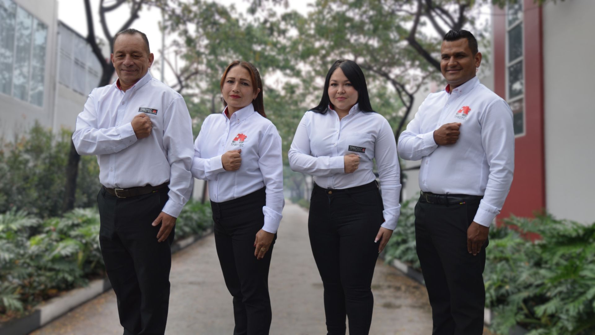 Un grupo de personas están paradas una al lado de la otra en una acera.