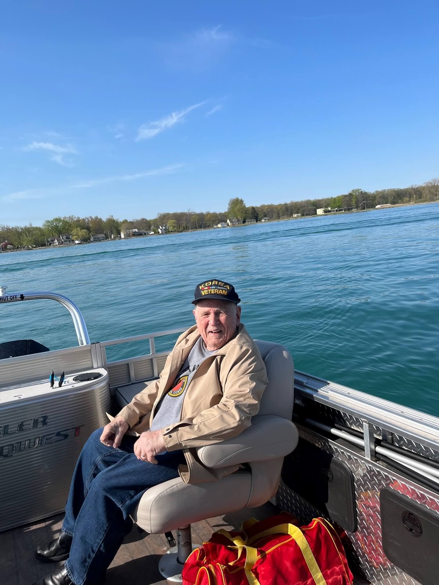 A man is sitting on a boat in the water.