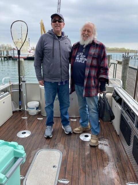Two men are standing on the deck of a boat