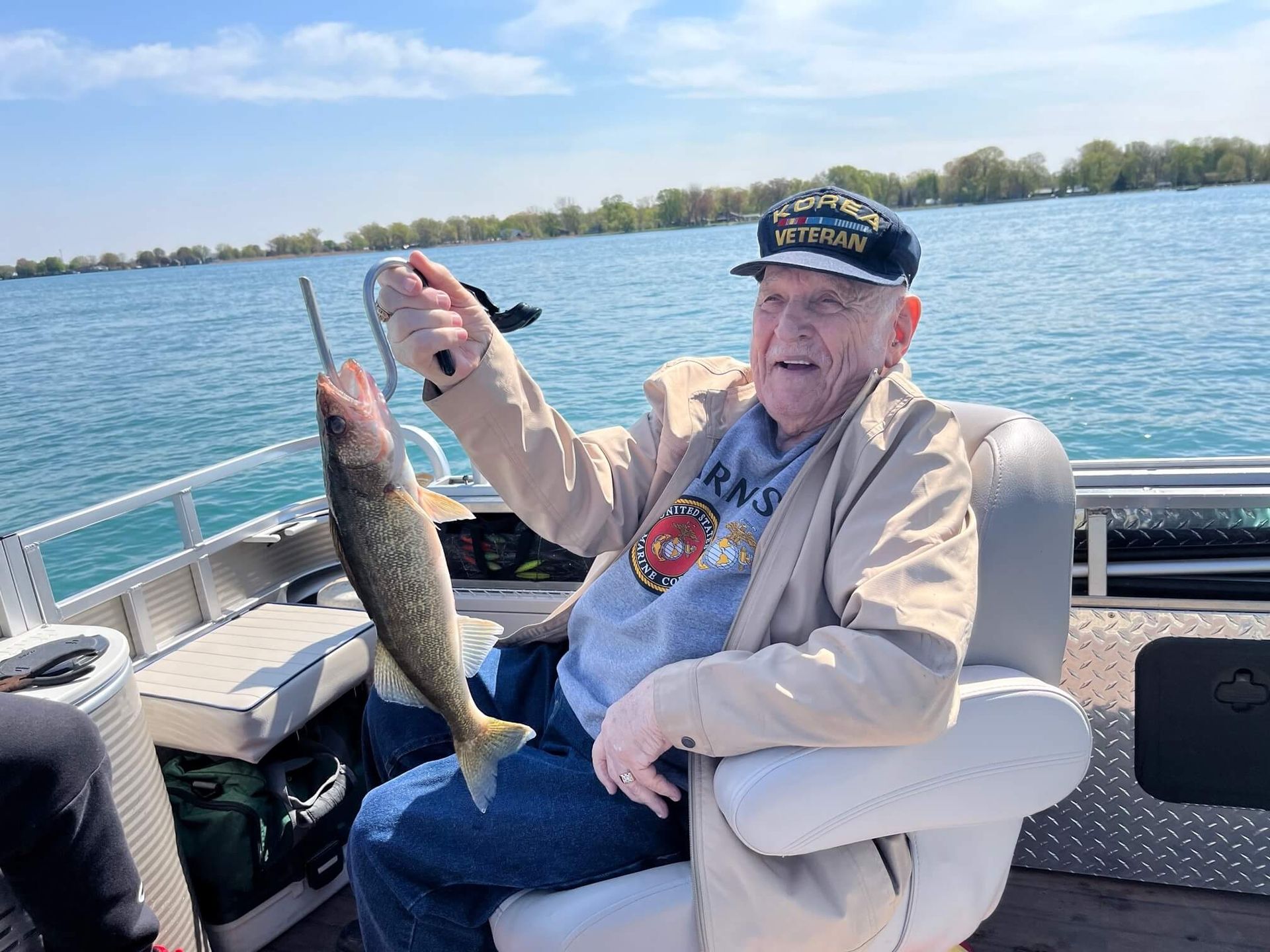A man is sitting on a boat holding a fish.