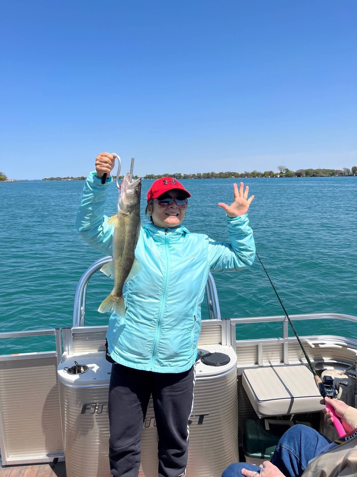 A woman is holding a fish on a boat.