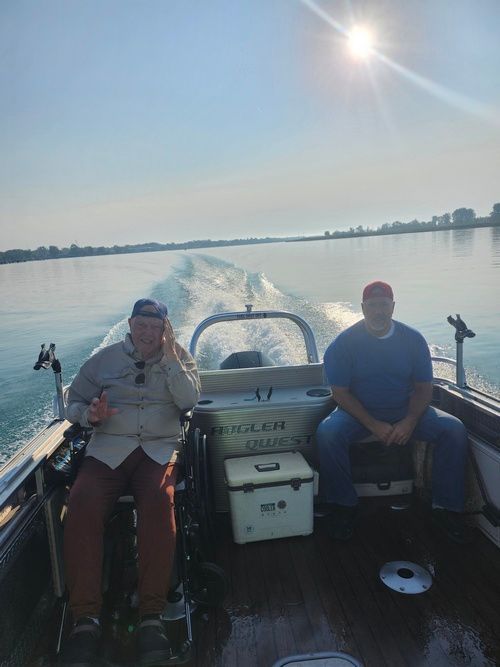 Two men are sitting in a boat on a lake.