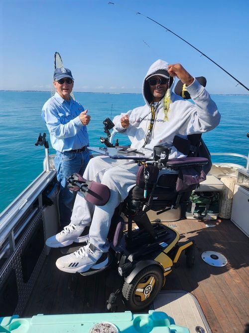 A man in a wheelchair is fishing on a boat.