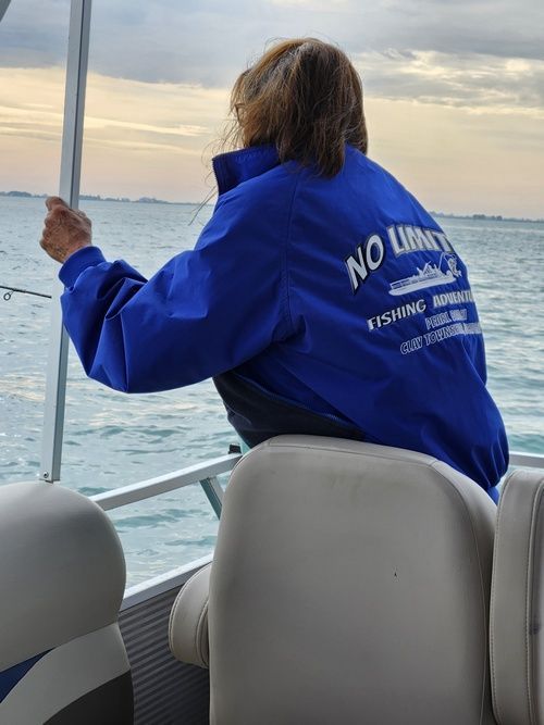 A person wearing a blue jacket that says no limits on it.