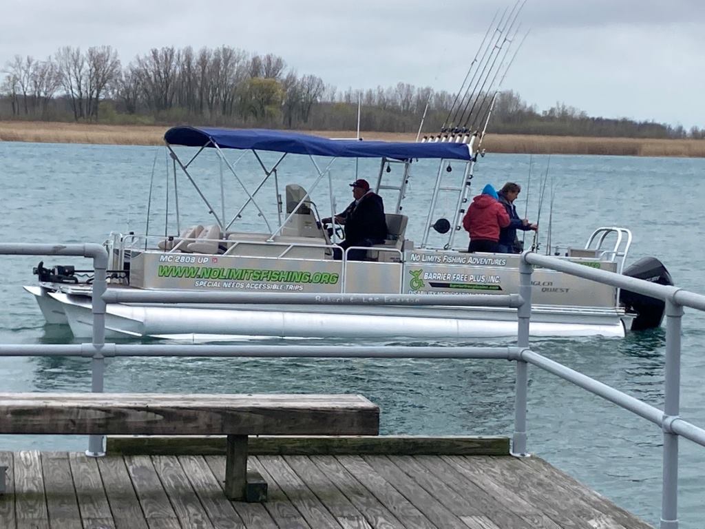 A boat is floating on a lake next to a dock.