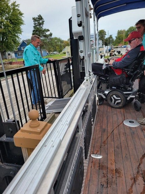 A man in a wheelchair is sitting on a boat.