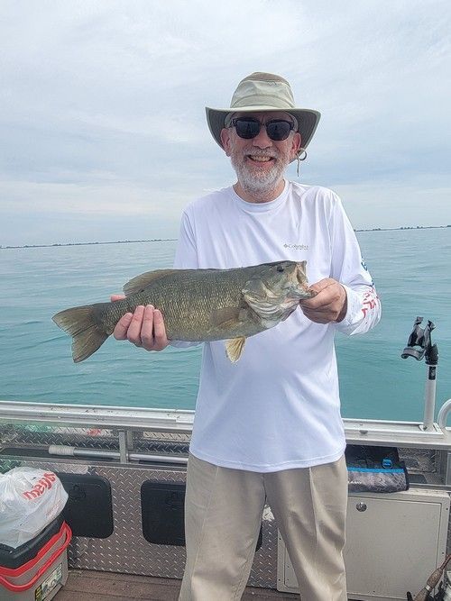 A man is holding a large fish on a boat.