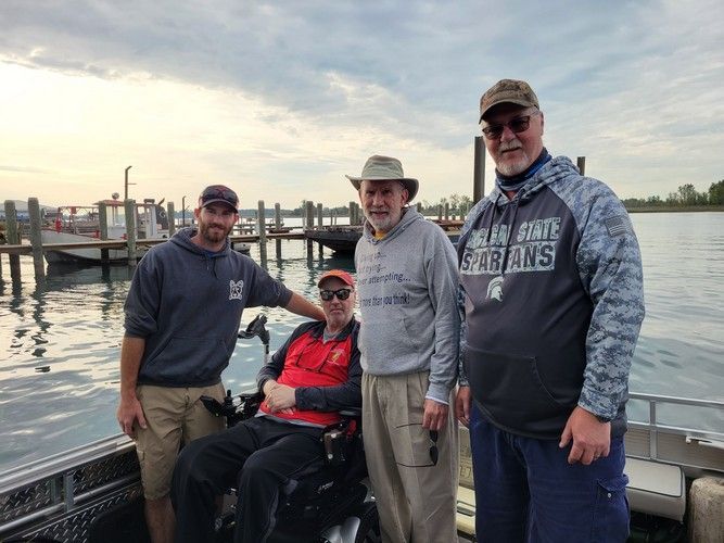 A group of men are standing next to a man in a wheelchair.