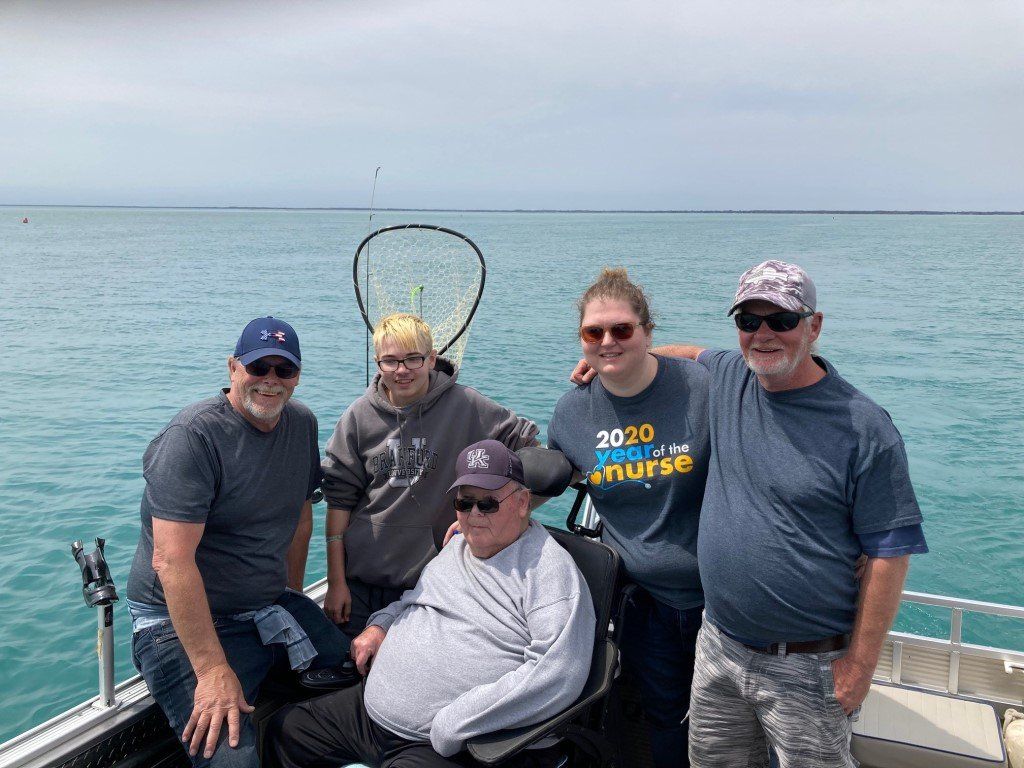 A group of people are standing on a boat in the water.