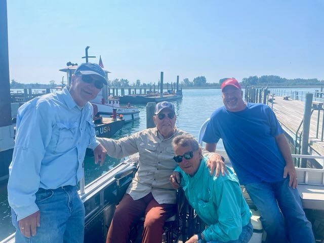 A group of men are posing for a picture on a boat.
