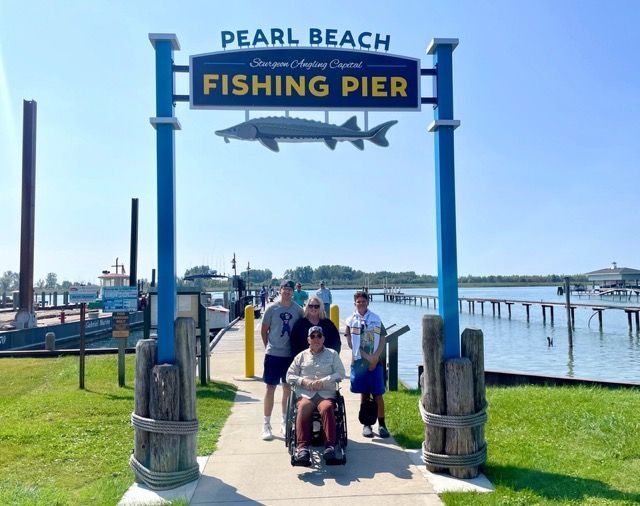 A man in a wheelchair is at the pearl beach fishing pier.