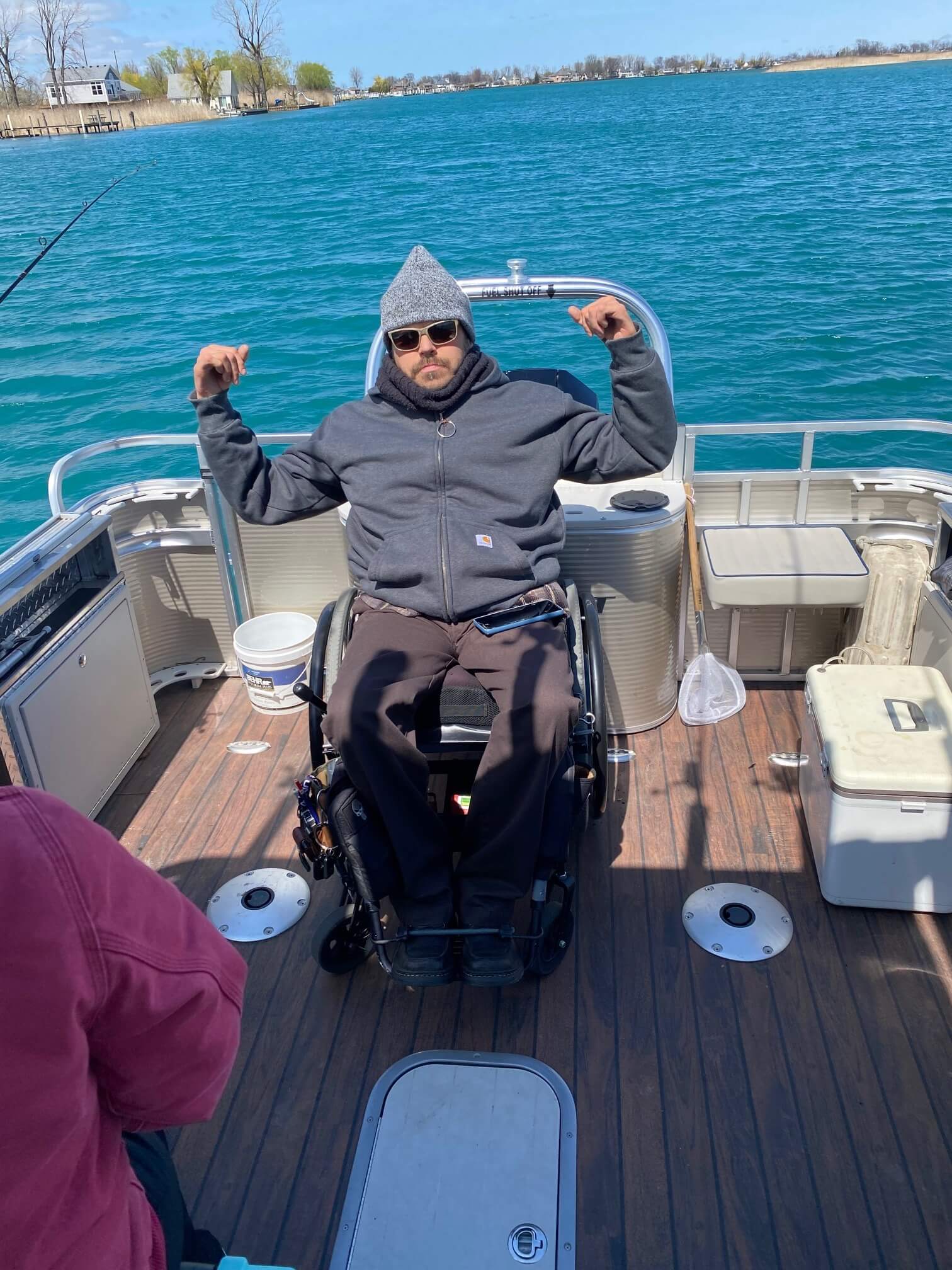 A man in a wheelchair is sitting on the back of a boat.