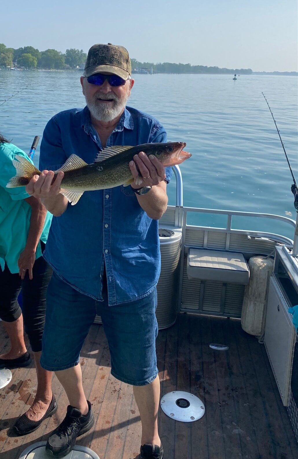 A man is holding a fish on a boat.