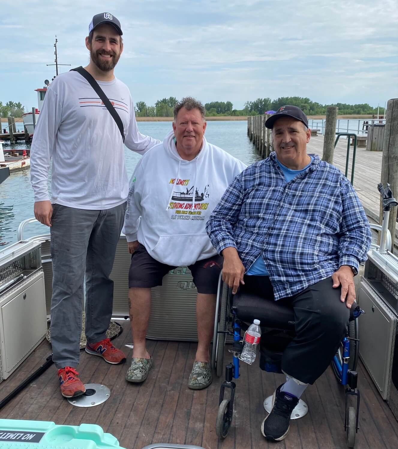 A man in a wheelchair is posing for a picture with two other men