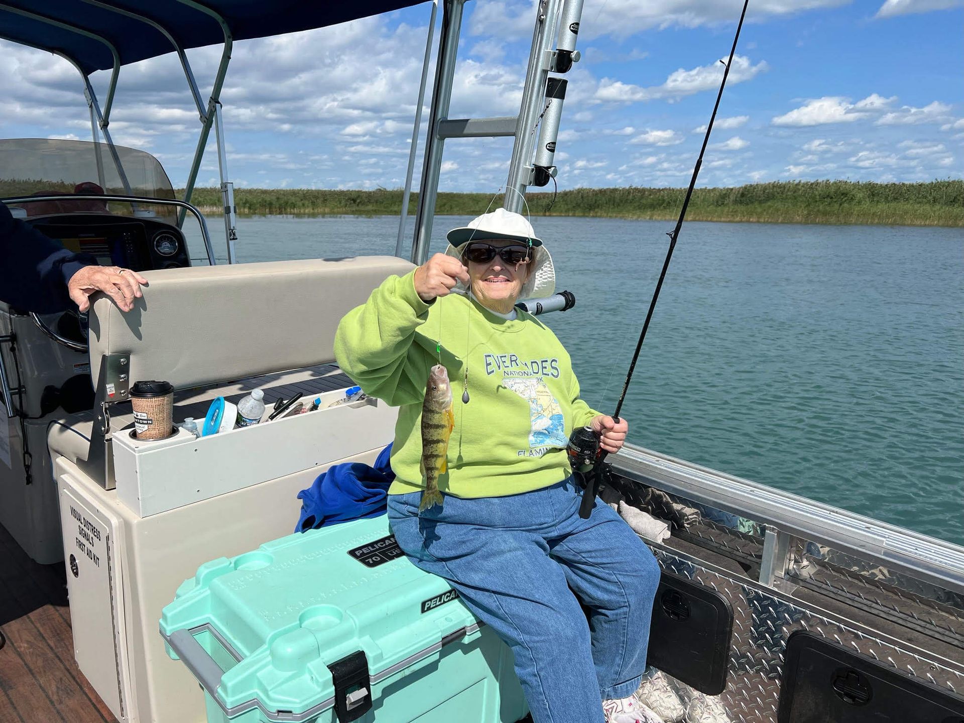 A woman is sitting on a boat holding a fish.