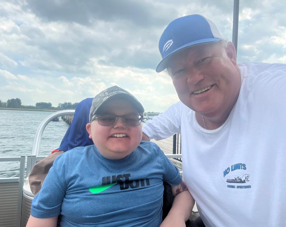 A man and a boy are posing for a picture on a boat.