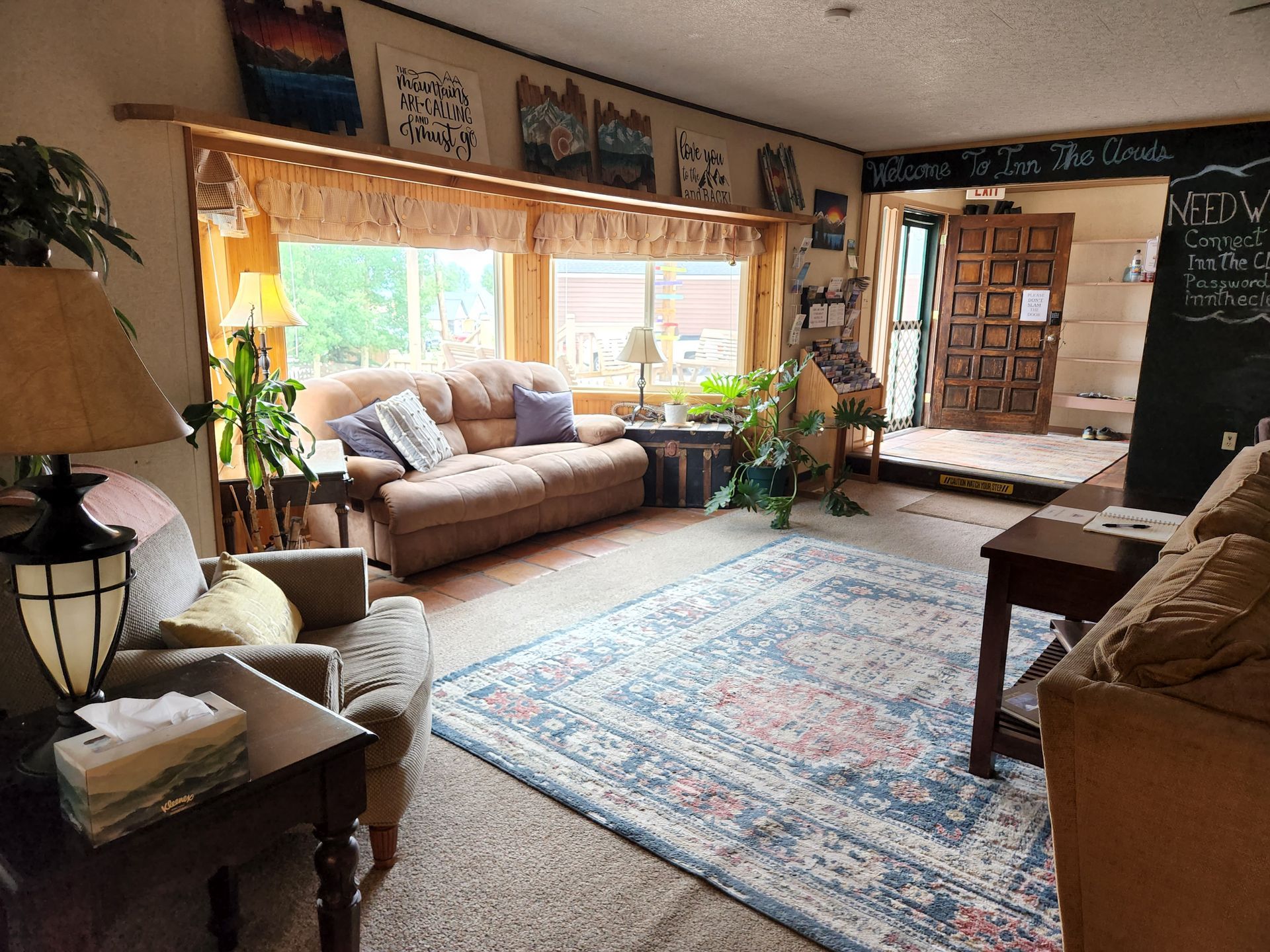 A living room with a couch and chairs and a rug