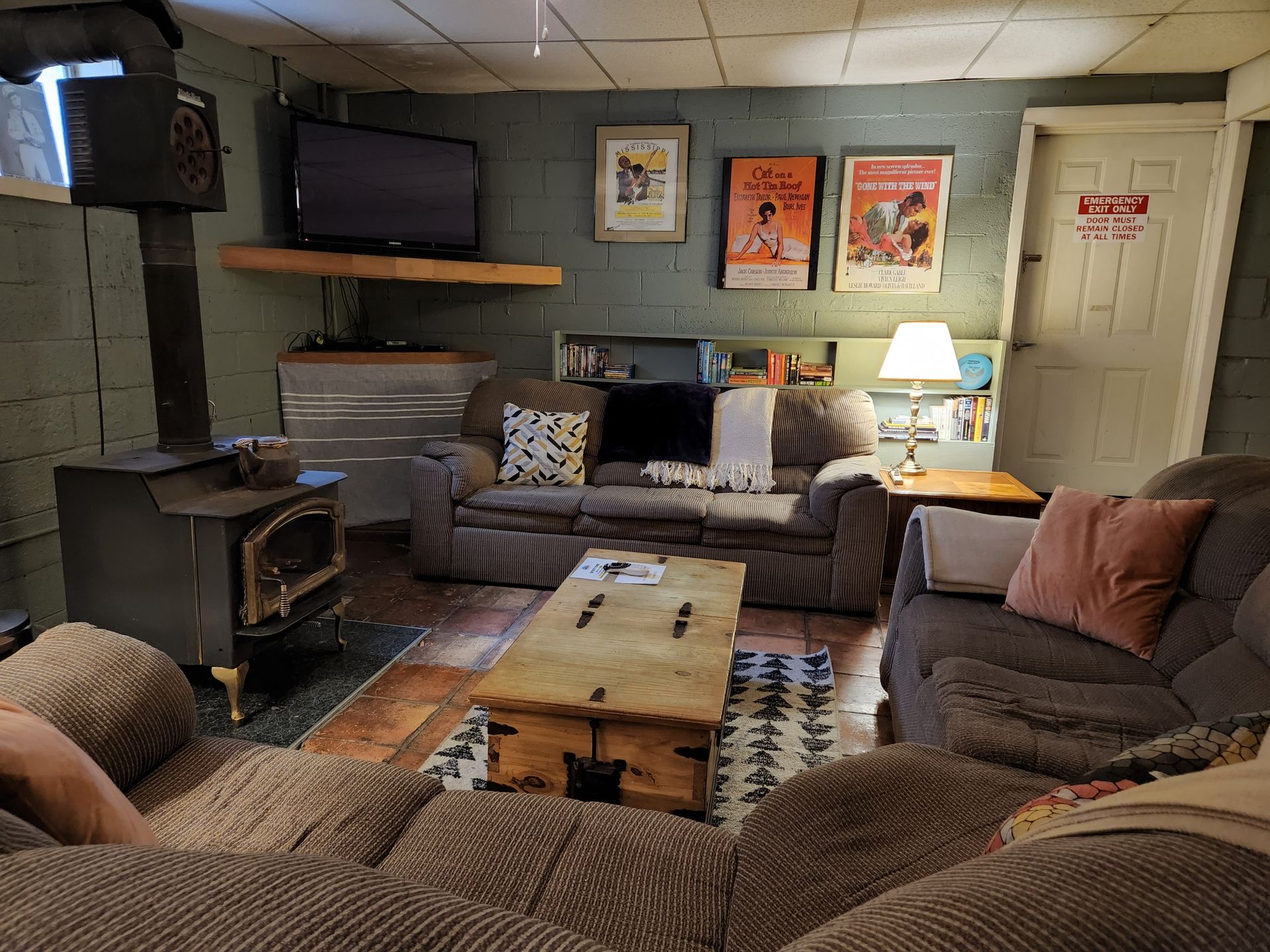 A living room with a couch , chairs , coffee table and television.