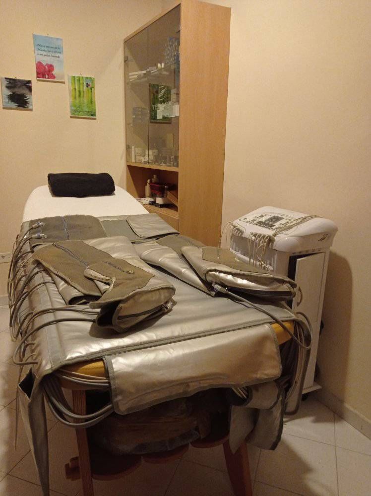 una donna riceve un manicure in un salone di bellezza mentre indossa guanti neri .