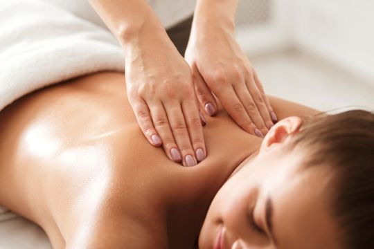 una donna sta ricevendo un massaggio al dorso da un massaggiatore .