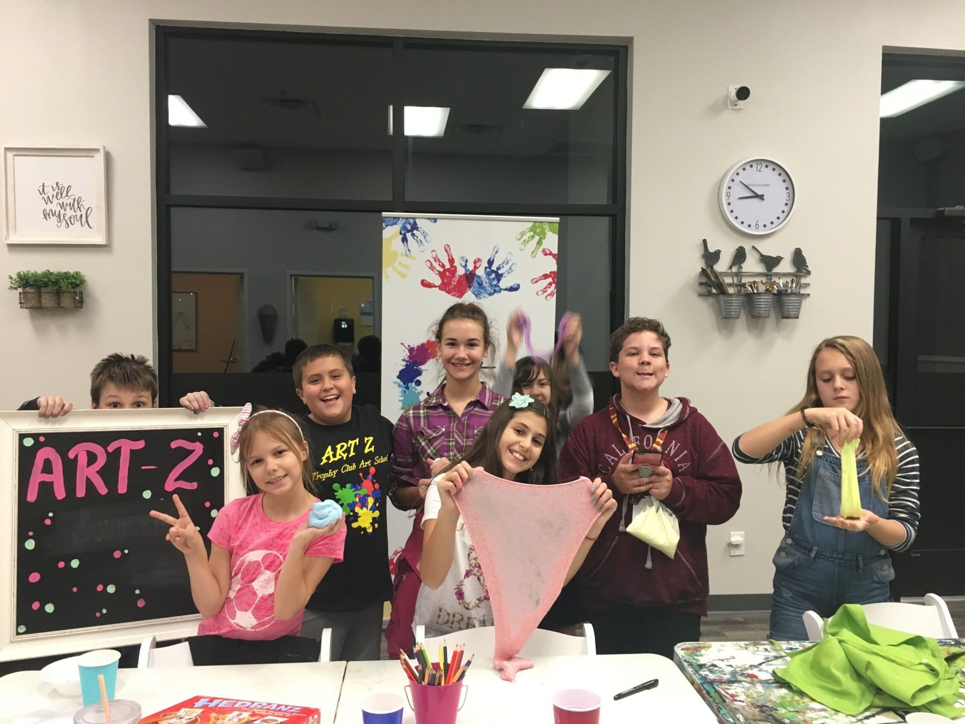 children posing with their art projects
