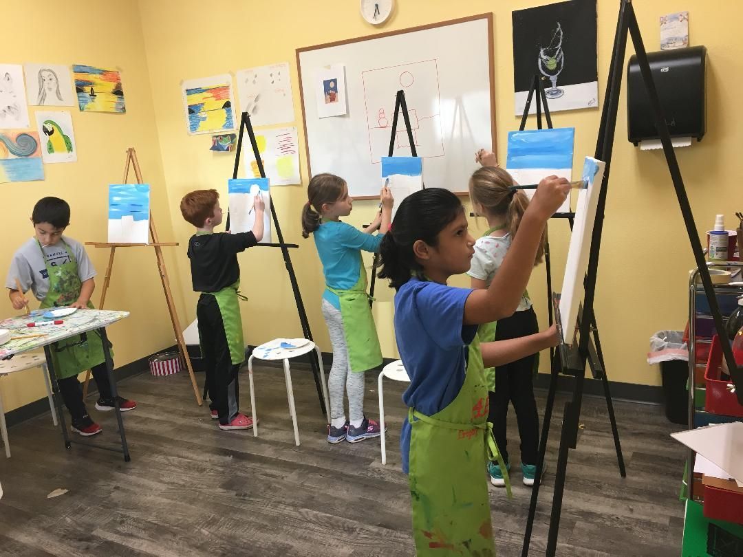 children painting on easels during art class