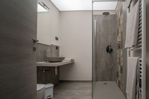 Un bagno con cabina doccia, lavandino, WC e specchio.