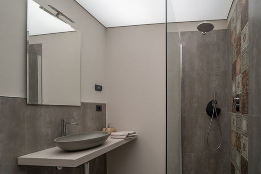 Un bagno con lavandino, specchio e cabina doccia.