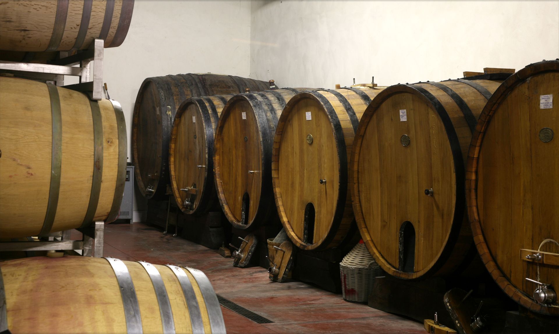 Una fila di botti di legno sono allineate in una stanza.