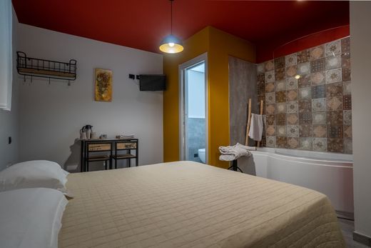 Una camera da letto con un letto, una scrivania, sedie e una vasca da bagno.
