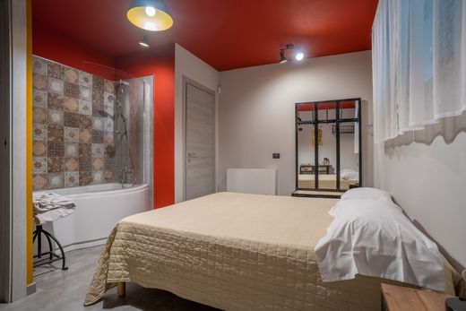 Una camera da letto con un letto, una vasca da bagno, uno specchio e un soffitto rosso.
