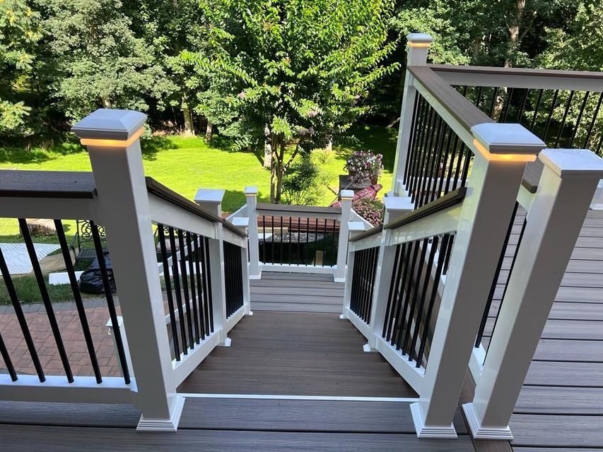 A set of stairs leading up to a deck with trees in the background.