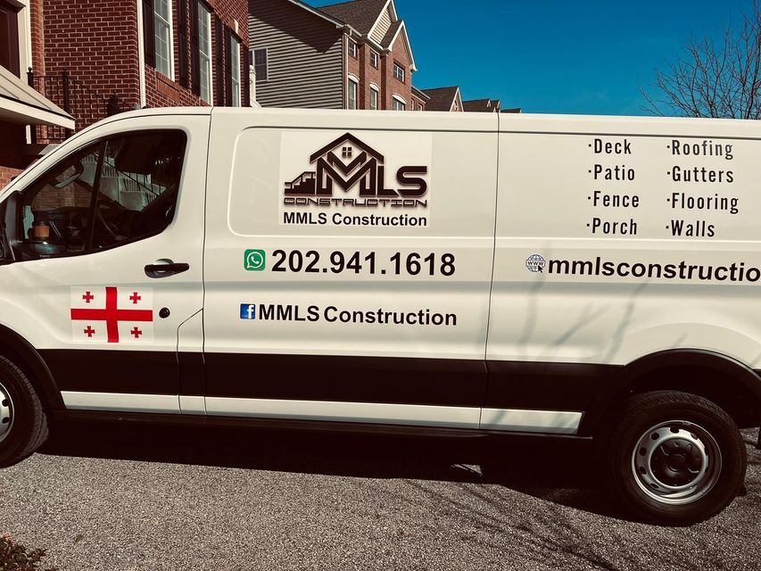 A white van is parked in front of a brick house.