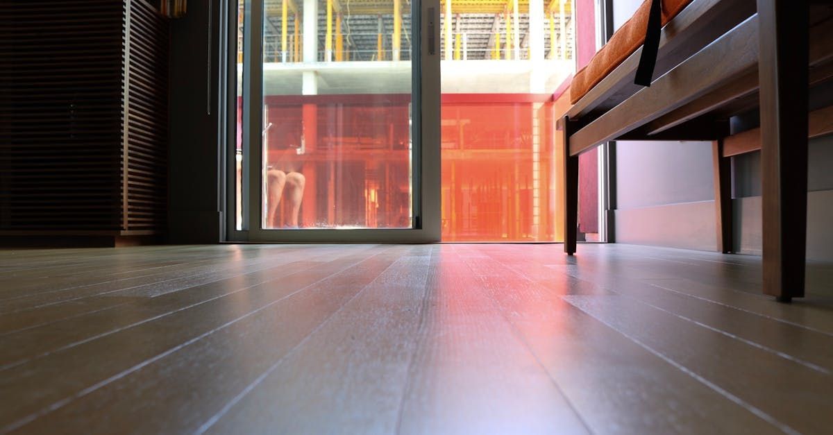 A wooden floor in a living room with a sliding glass door.