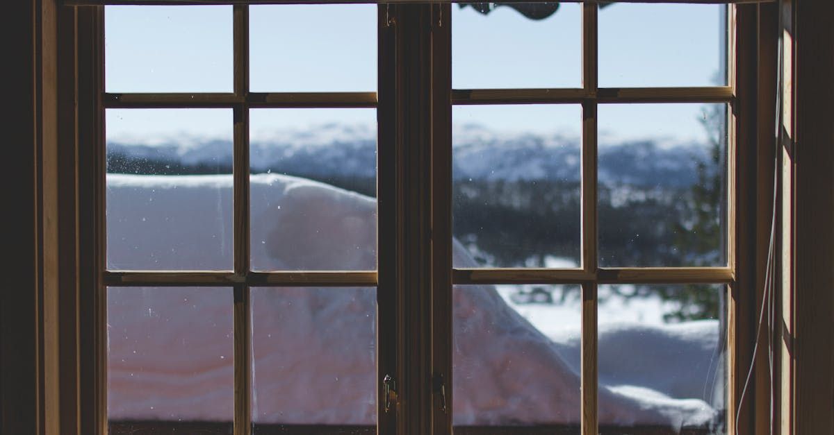 A window with a view of a snowy mountain range.