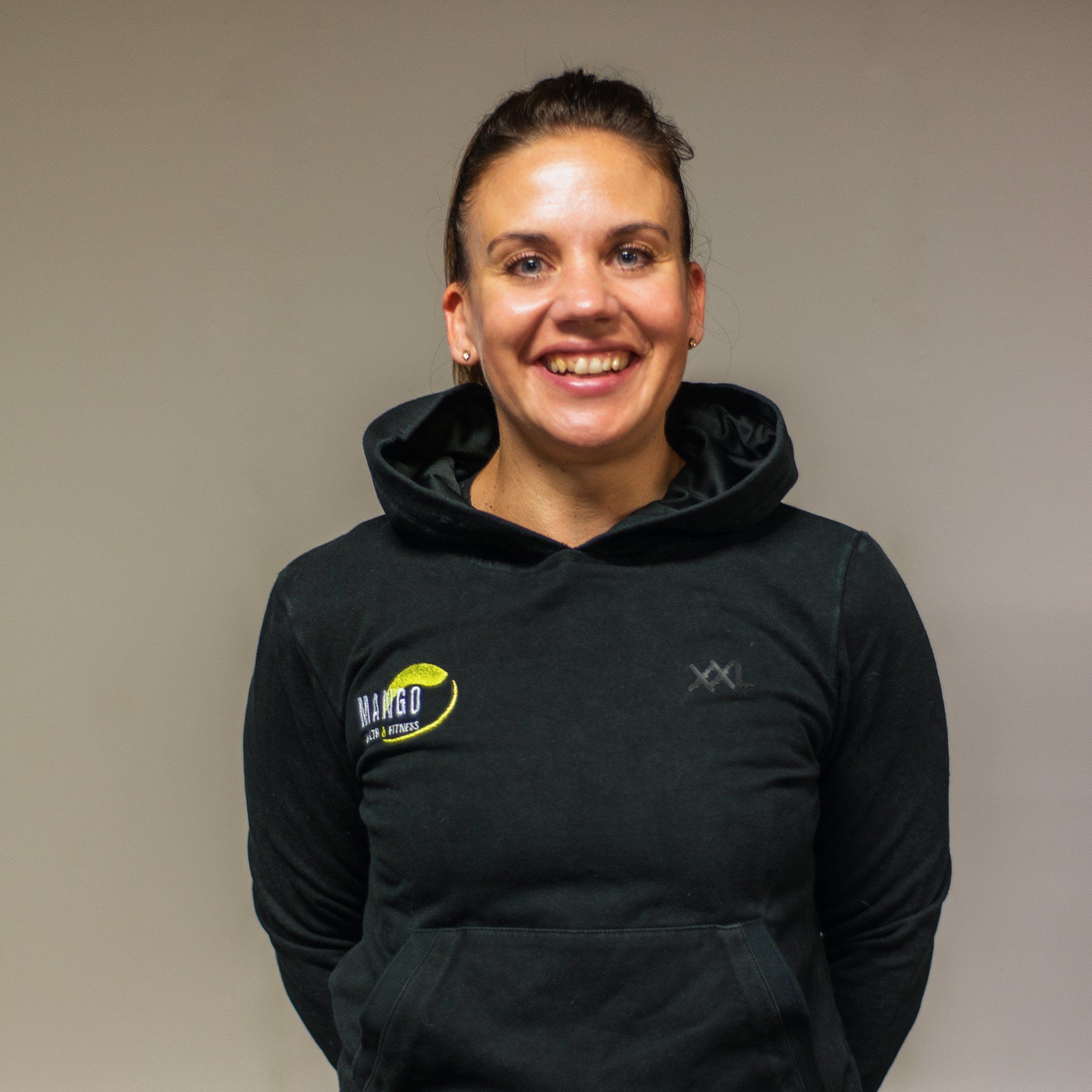 Een vrouw draagt ​​een zwarte hoodie met een geel logo erop