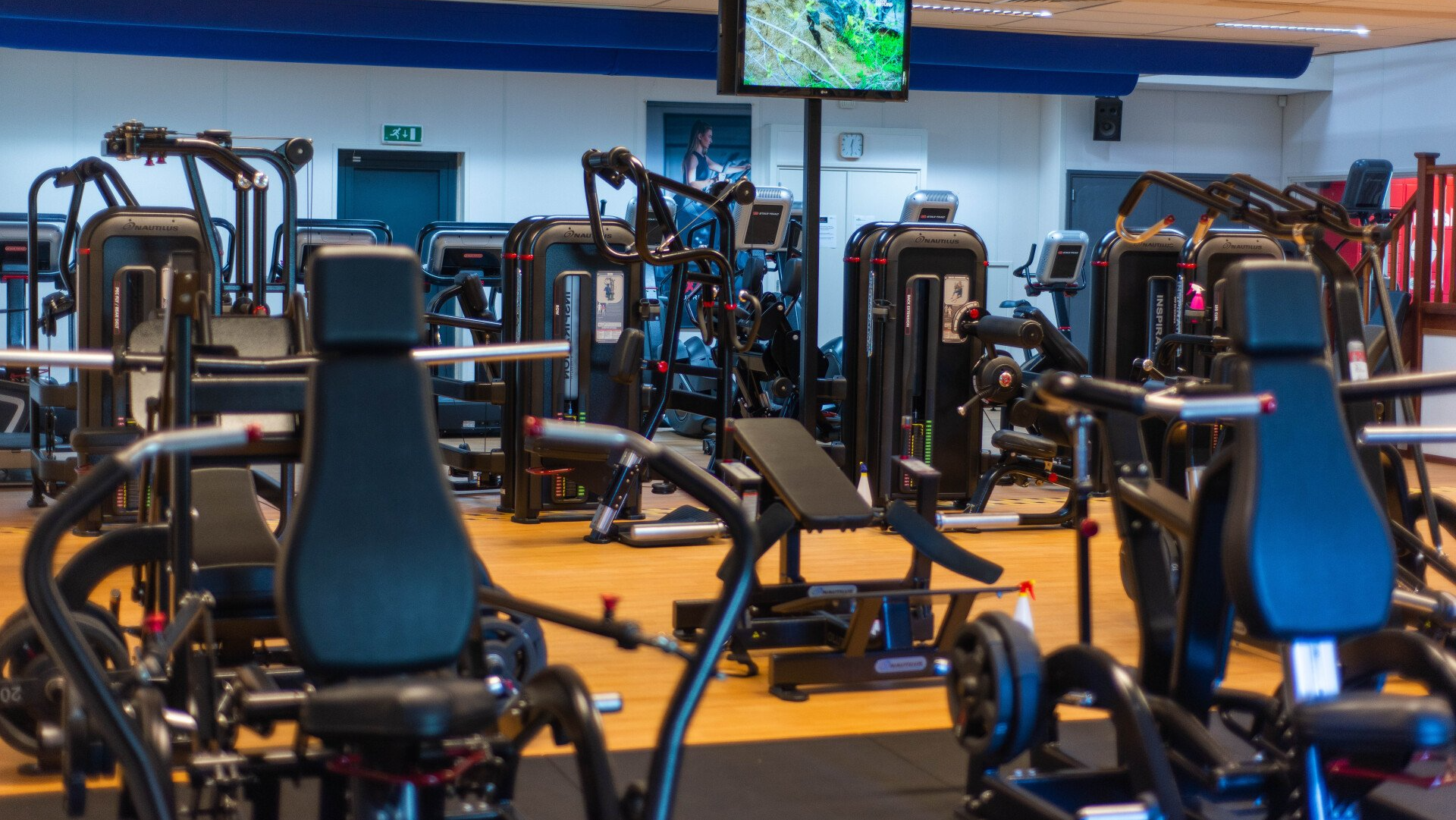 Een fitnessruimte vol met veel fitnessapparatuur en een televisie.