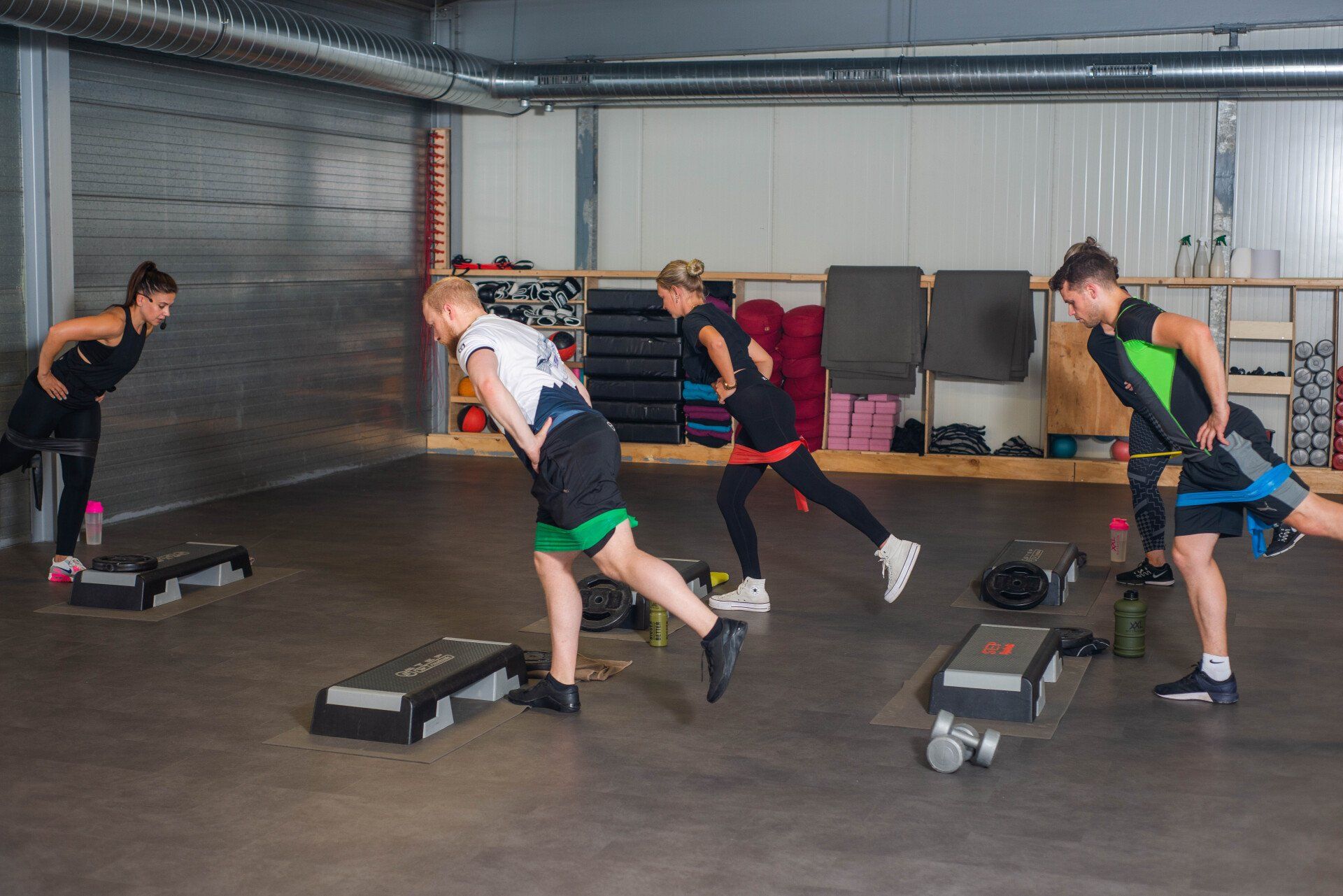 Een groep mensen doet oefeningen in een sportschool.