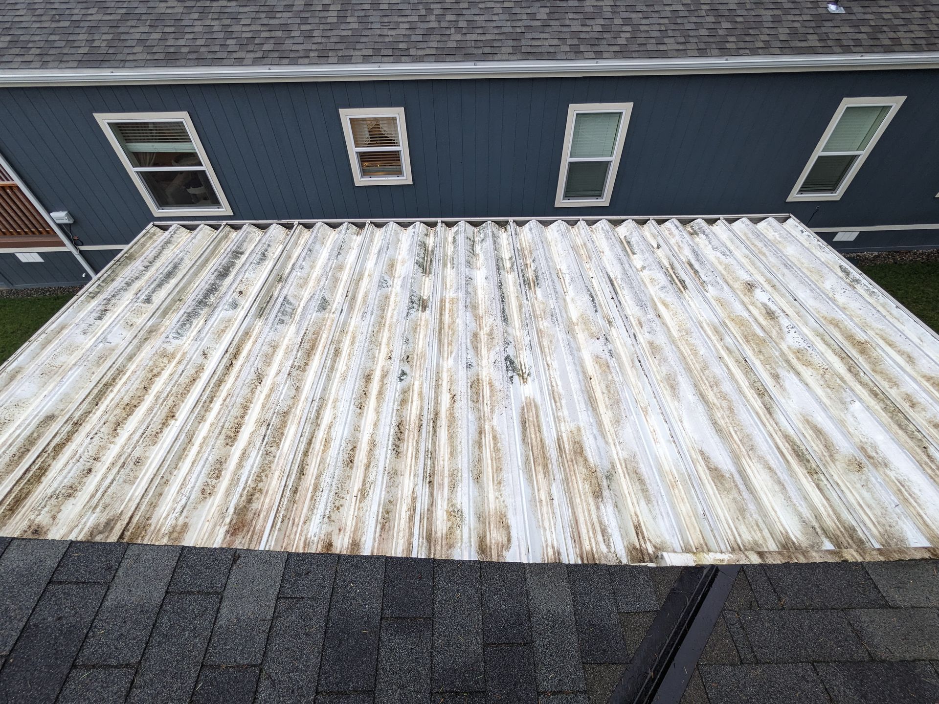 A large piece of metal is sitting on top of a roof in front of a house.