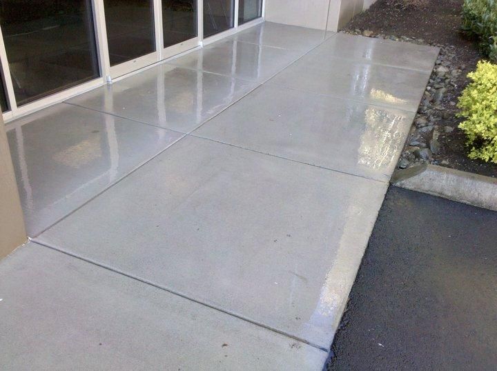 A concrete walkway next to a building with a lot of windows.