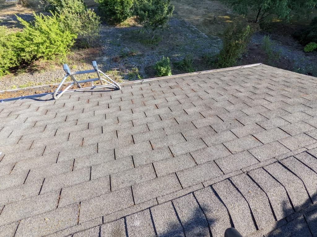 A ladder is sitting on the roof of a house.