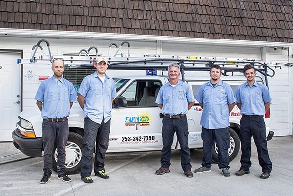 A group of men are standing in front of a white van.