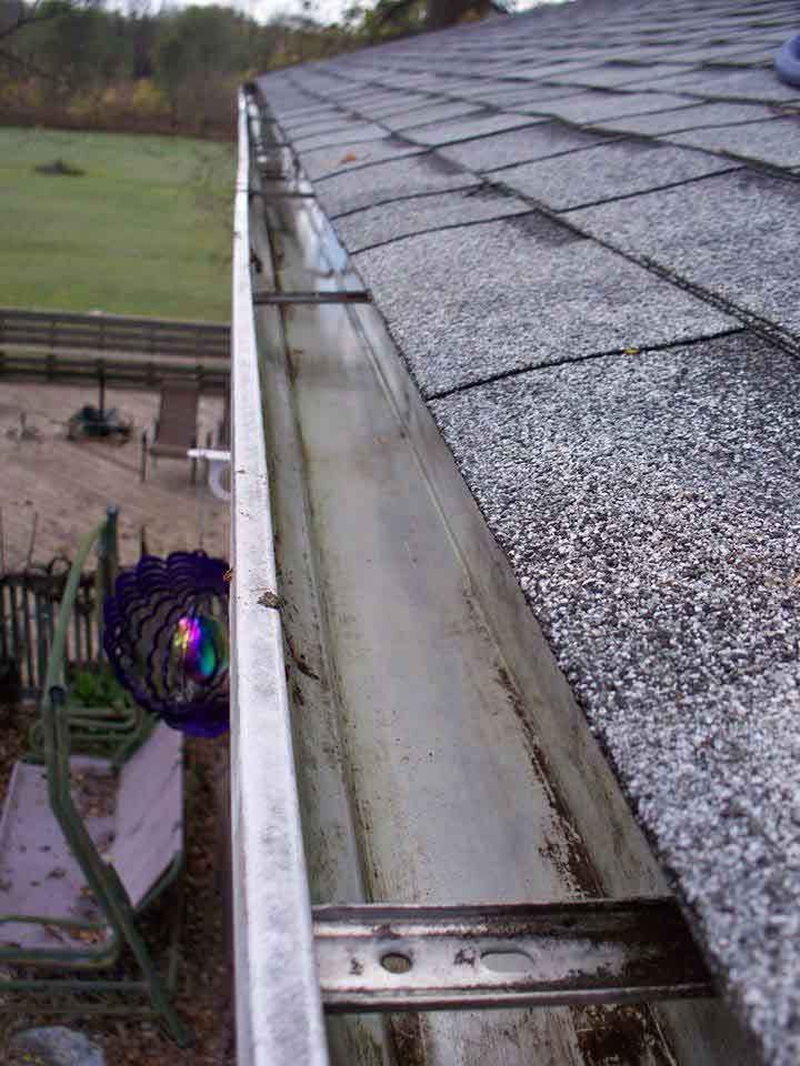 A gutter is sitting on top of a roof next to a playground.