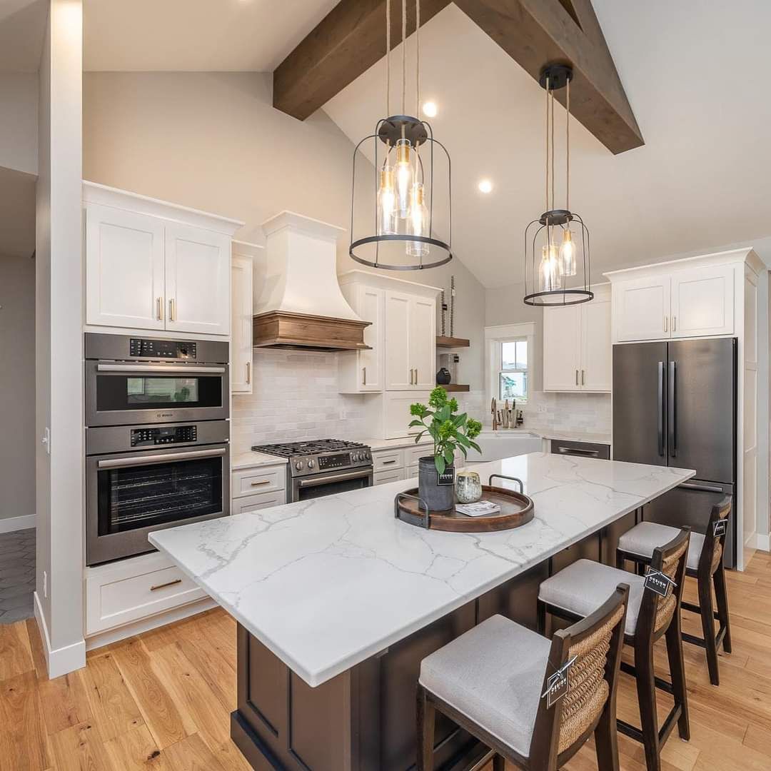 Man in black shirt holding coffee mug, smiling in a kitchen.