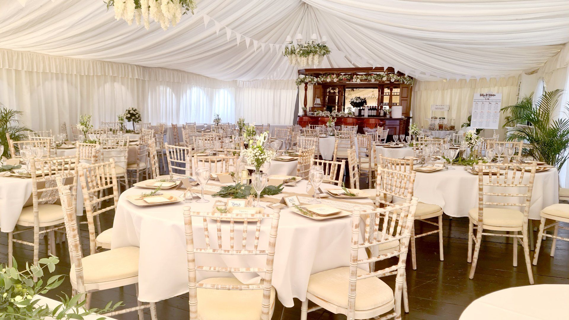 A large marquee with tables and chairs set up for a wedding reception at the West Usk Lighthouse.