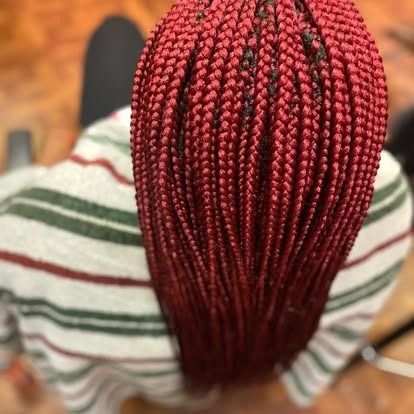 Top view of long red braided hair on a person wearing a striped shirt.